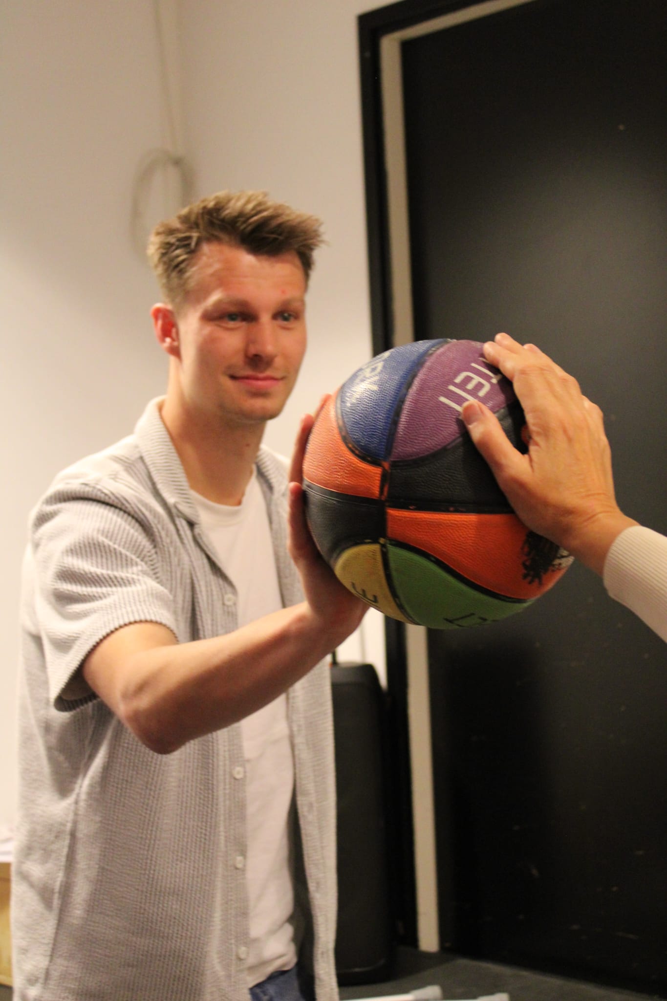 Medewerker van Buro J.A.Z.Z. met een basketbal
